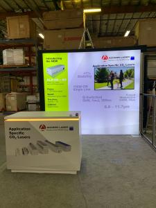 RENTAL: RE-1079 Inline Design with 110" Wide x 96" High Single-Sided Lightbox, Large Monitor Mount, 50" Monitor, RE-1576 Reception Counter, SEG Backlit Fabric Graphic, and Vinyl Applied Graphic